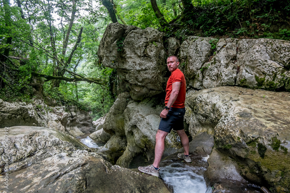 A male traveler admires the canyon of the Agura River in Sochi.