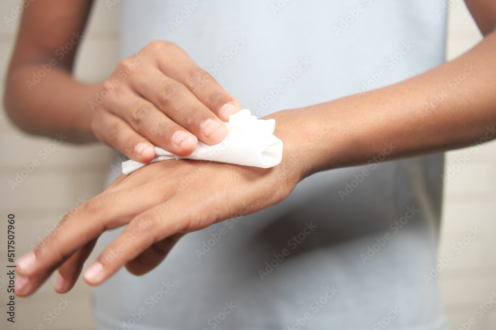 man disinfecting his hands with a wet wipe. man disinfecting his hands with a wet wipe.