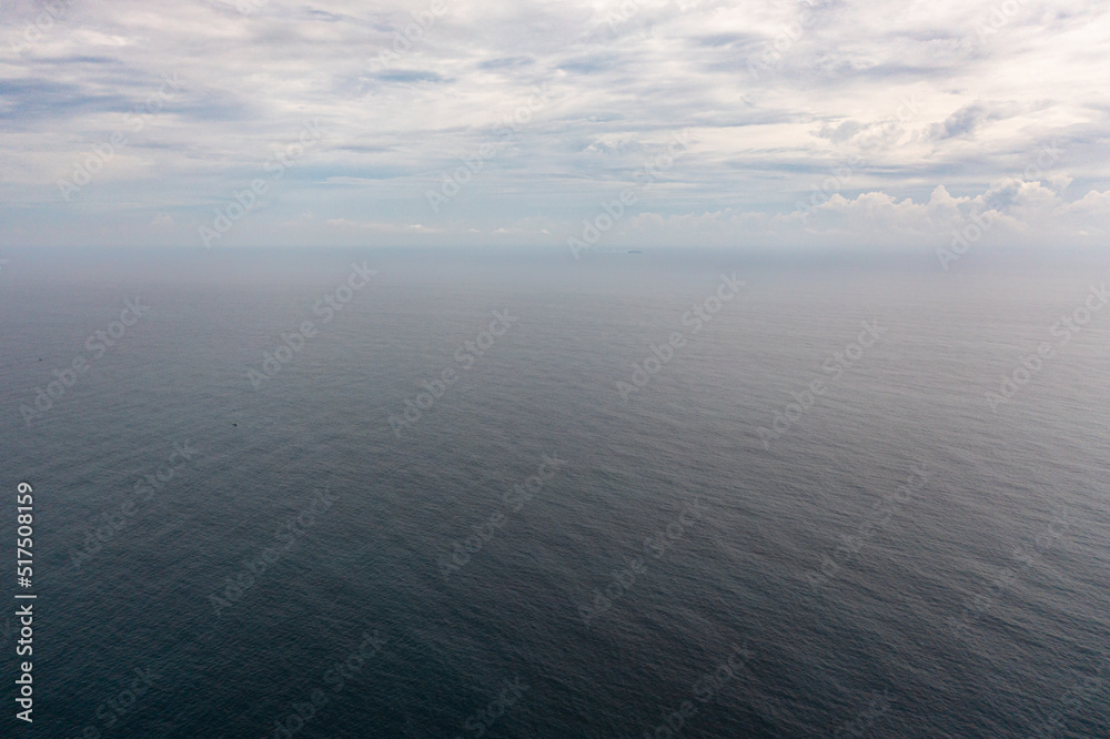 Top view of blue sea with waves and sky with clouds. Ocean skyline.