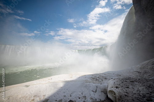Horseshoe Falls at Niagara Falls Canada are pouring water through frozen landscape at winter