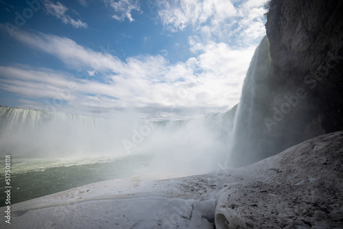 Horseshoe Falls at Niagara Falls Canada are pouring water through frozen landscape at winter