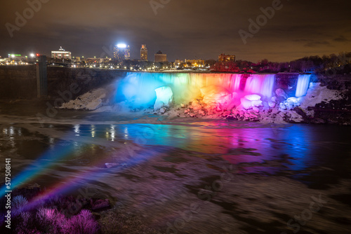Night illumination on Horseshoe Falls at Niagara Falls Canada are pouring water through frozen landscape at winter