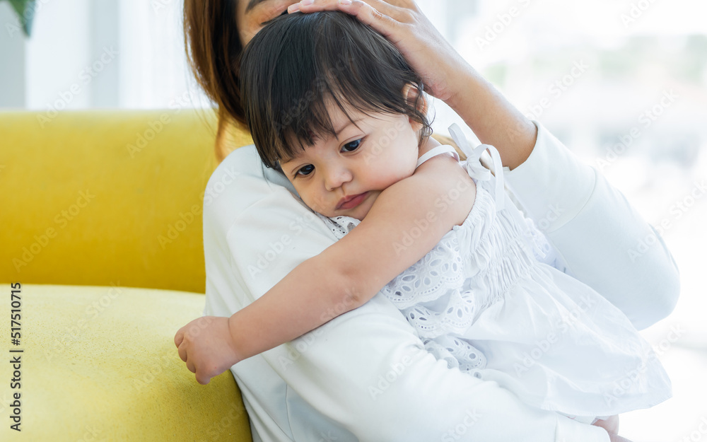 Mother holding and hugging adorable caucasian little baby daughter girl, playing together wiht happiness and warmth, staying in comfortable living room at home. Family and Kid Concept. Mother holding and hugging adorable caucasian little baby daughter girl, playing together wiht happiness and warmth, staying in comfortable living room at home. Family and Kid Concept.