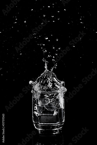 Ice falling in a glass of water.
