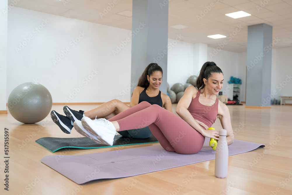 TWO GIRLS TRAINING YOGA AND PILATES TOGETHER WITH A BALL AND WEIGHTS TWO GIRLS TRAINING YOGA AND PILATES TOGETHER WITH A BALL AND WEIGHTS