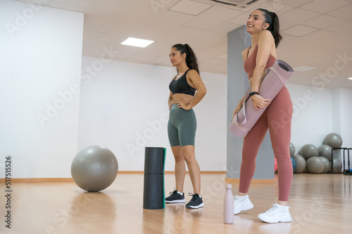 TWO GIRLS TRAINING YOGA AND PILATES TOGETHER WITH A BALL AND WEIGHTS