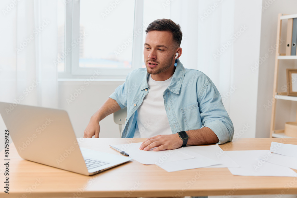 Smiling happy friendly good-looking young businessman conducts a job interview remotely using laptop in office. Copy space for ad. Remote Job, Technology And Career Profession Concept Smiling happy friendly good-looking young businessman conducts a job interview remotely using laptop in office. Copy space for ad. Remote Job, Technology And Career Profession Concept