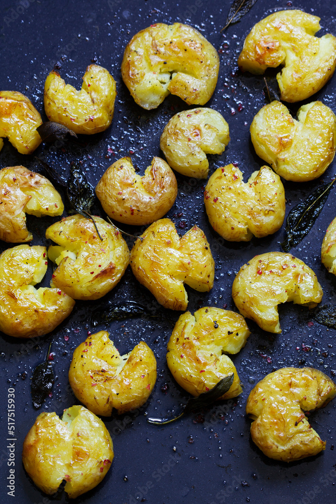 Broken potatoes baked in oil with herbs and sauce.
