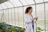 Scientist female use mobile phone in greenhouse vegetable in organic farm