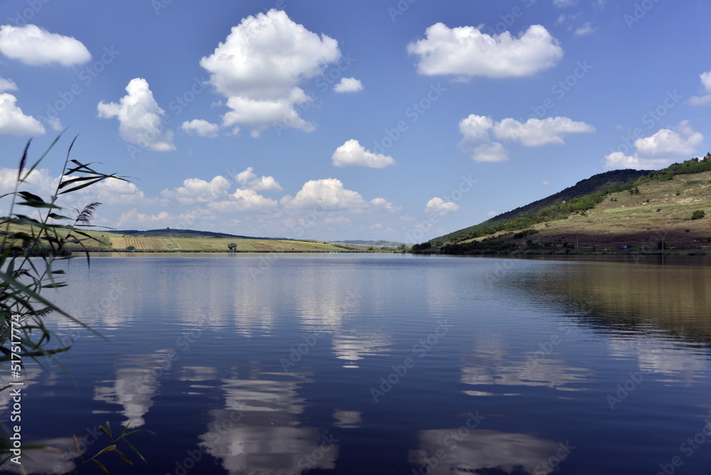 Cumulus clouds between a blue sky ans lake waters