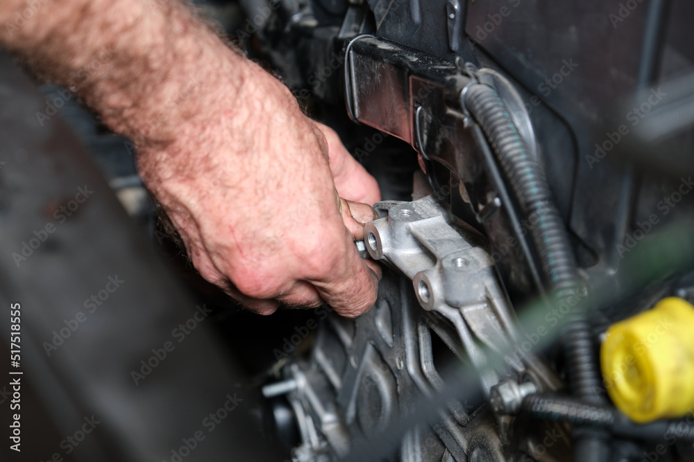 Foto Stock Auto mechanic hands screws the engine mount after replace ...