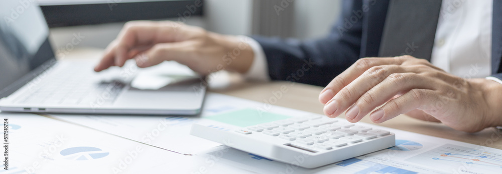 Businessman presses a calculator to calculate earnings and analyze company earnings in his private office, Information in finance and accounting, Company performance and revenue. Businessman presses a calculator to calculate earnings and analyze company earnings in his private office, Information in finance and accounting, Company performance and revenue.