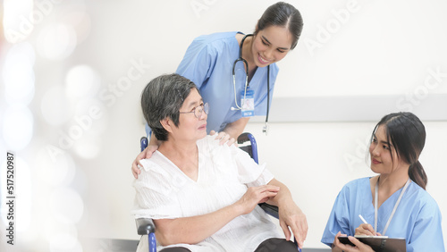 Senior patient with young doctor. patient in a wheelchair with relatives of the patient listening. nurse.