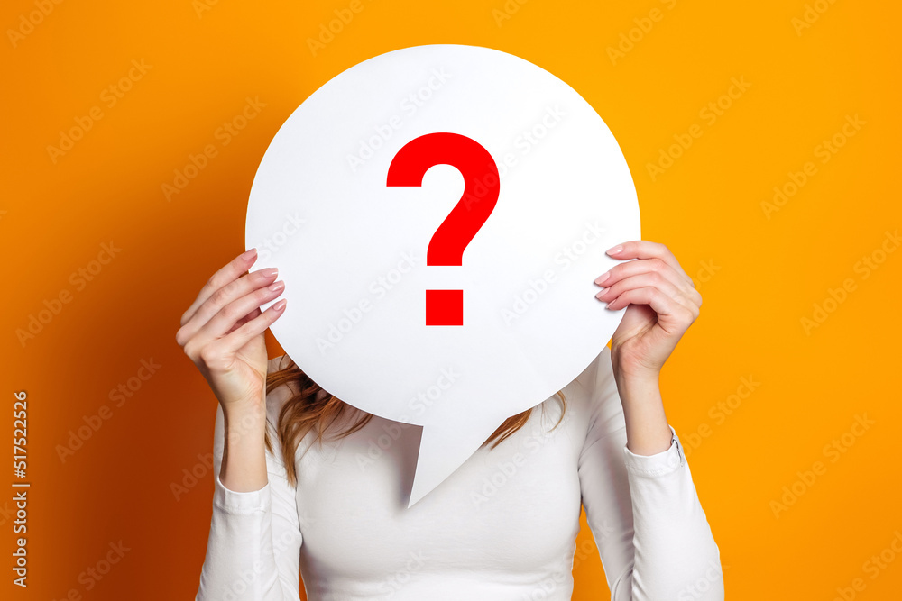girl wearing white t-shirt holding paper card bubble with question mark isolated over orange background girl wearing white t-shirt holding paper card bubble with question mark isolated over orange background