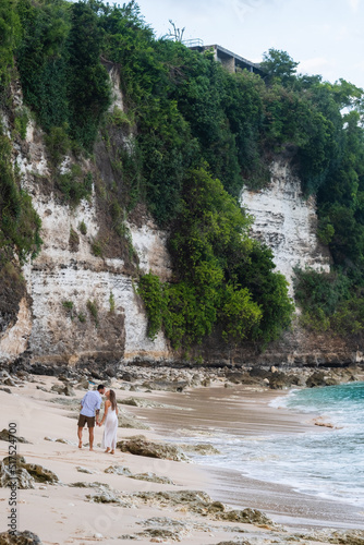 Сouple in love walking on the beach, uluwatu, Bali.