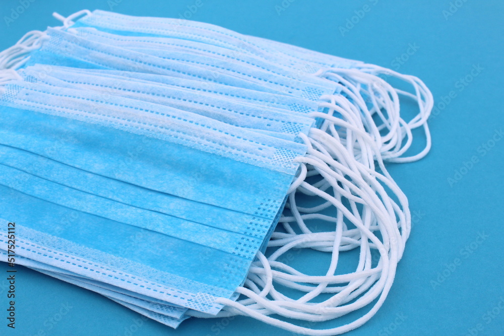 The medical mask lies on a blue background. The medical mask lies on a blue background.
