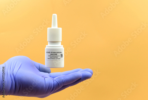 Hand of a doctor or scientist under a tube of a nasal vaccine against the coronavirus that causes COVID-19