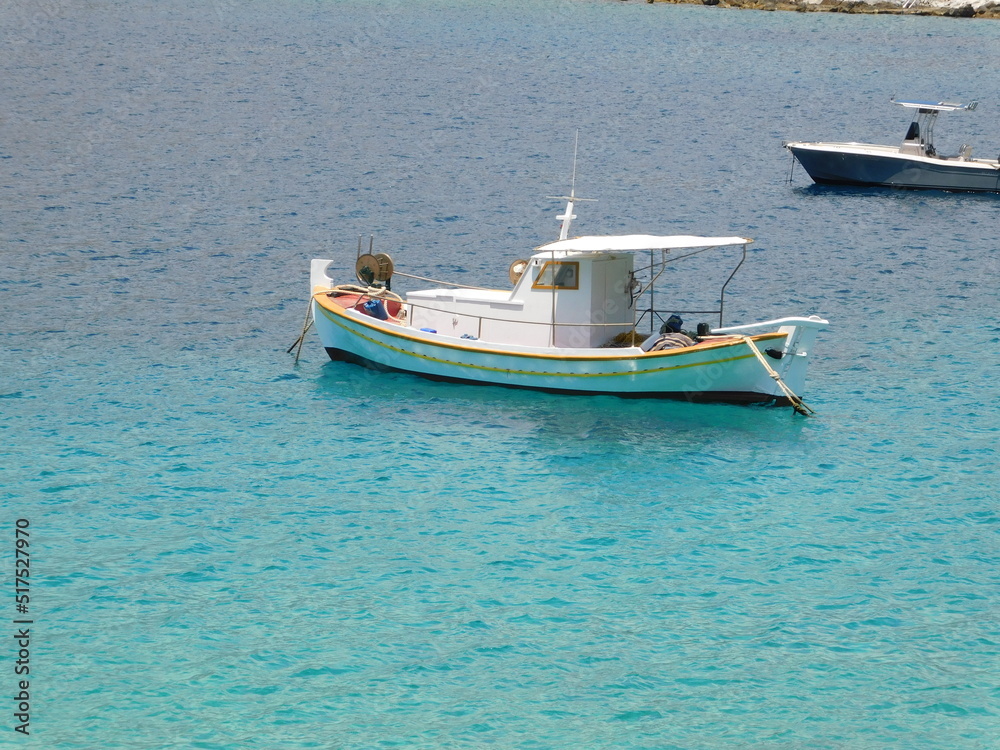 A white fishing boat on a turquoise and blue sea, at Limeni, Mani, Greece