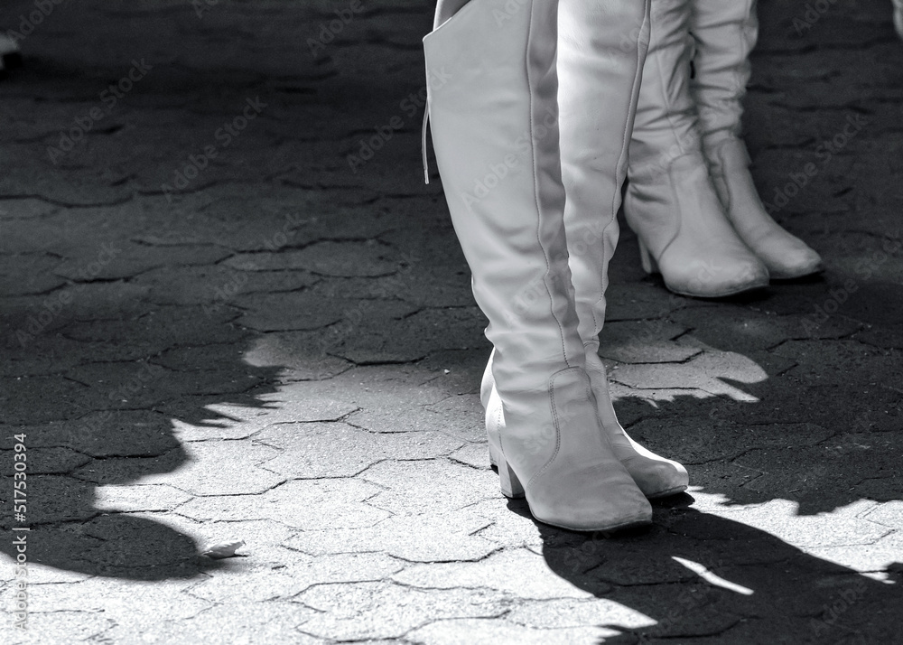 High white boots on the feet of the members of the majorette team. High white boots on the feet of the members of the majorette team.