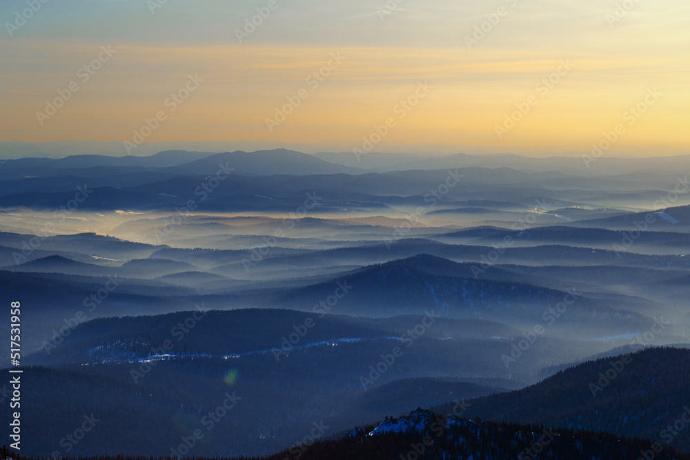 Colorful mountain hills with tonal perspective at winter evening at sunset. Abstract panoramic landscape in Gornaya Shoria, Sheregesh ski resort in Russia Foggy Mountains nature background