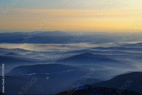 Colorful mountain hills with tonal perspective at winter evening at sunset. Abstract panoramic landscape in Gornaya Shoria  Sheregesh ski resort in Russia Foggy Mountains nature background