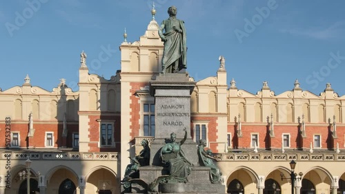 Statue of Adam Mickiewicz and Sukiennice buidning in Cracow, Poland photo