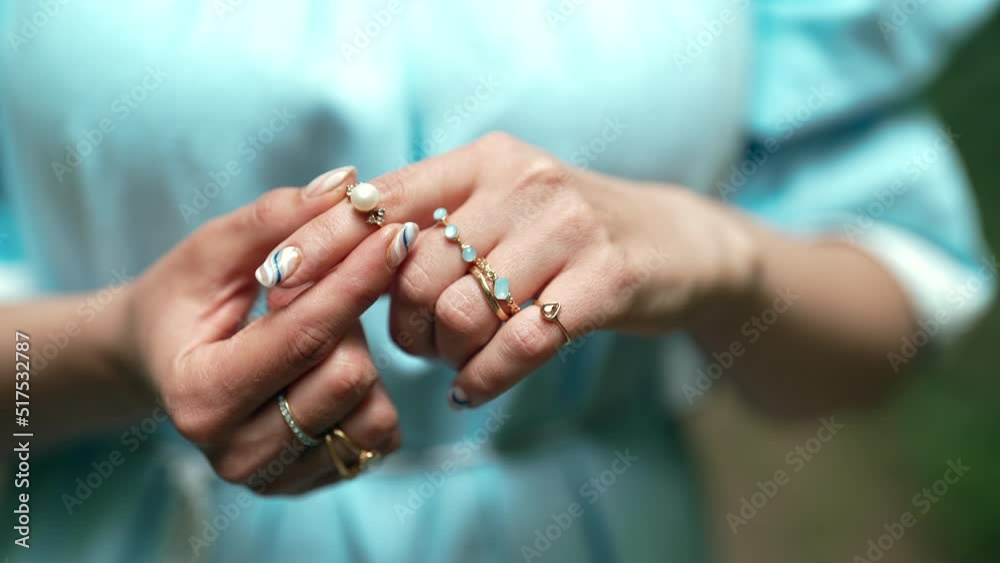 Beautiful gypsy woman wears exquisite jewelry on fingers - gold rings with natural stones, boho jewelry. Girl in blue dress. Beautiful gypsy woman wears exquisite jewelry on fingers - gold rings with natural stones, boho jewelry. Girl in blue dress.