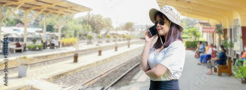 Female tourists   talking on the phone at a railway station photo