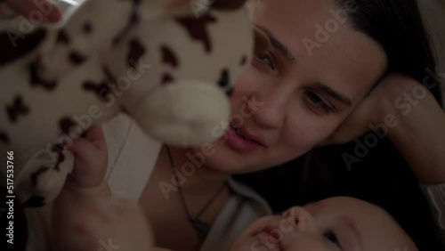 Newborn Baby With Young Mom look Into Each Other Eye. Cute Smiling Teethless Kid Face Portrait. Woman Kissing With Child Look At Camera. Infant, Mother Day, Childbirth, Beginning, Relationship Concept photo