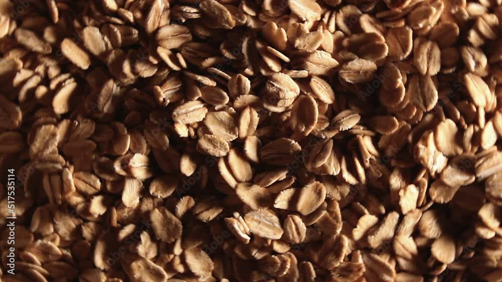 Oat Flakes Background Rotating Left - Top View, Low Key Light. Scattered Dry Oat Flakes. Healthy Breakfast and Diet Eating Ingredients Oat Flakes Background Rotating Left - Top View, Low Key Light. Scattered Dry Oat Flakes. Healthy Breakfast and Diet Eating Ingredients