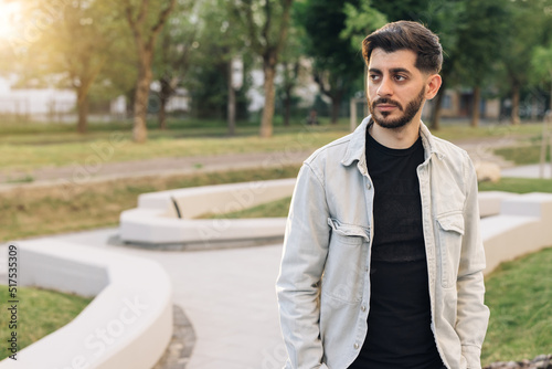 Bearded mixed-race elegant man with brown eyes. Caucasian european man looking stright outdoors. Stand outdoor relax. Happy relax. Male portraits