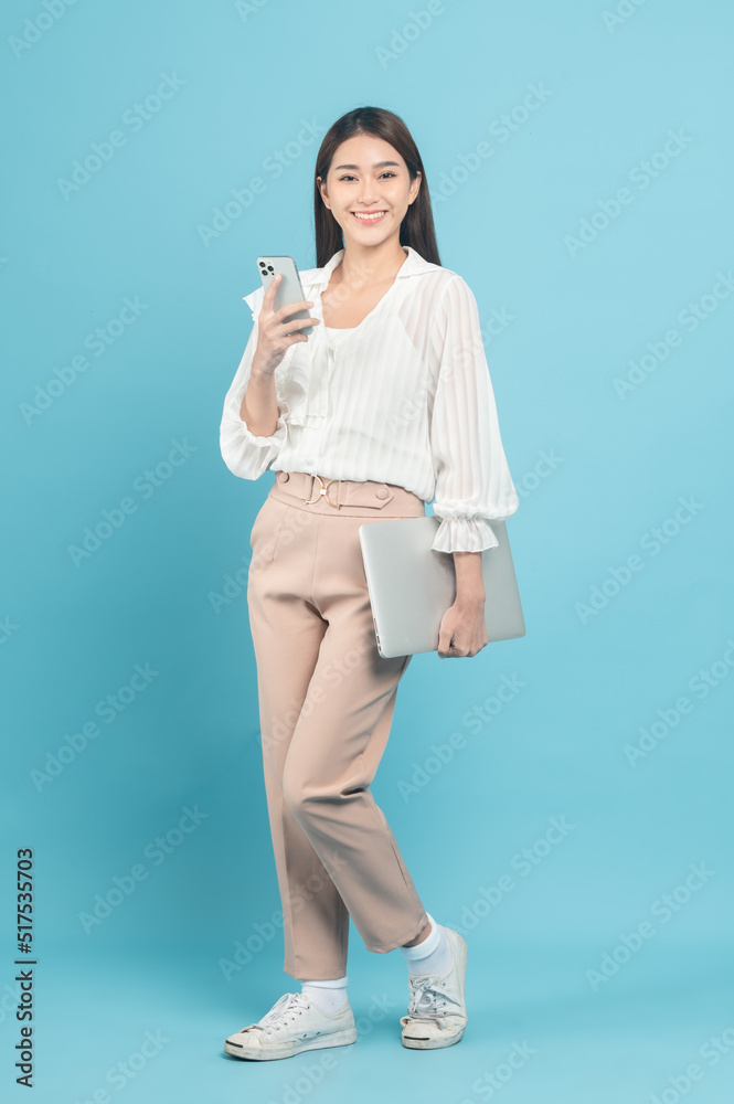 Young beautiful asian woman with smart casual cloth use smartphone isolated on blue background Young beautiful asian woman with smart casual cloth use smartphone isolated on blue background