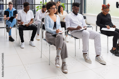 Group of diverse young people sitting in a conference room.