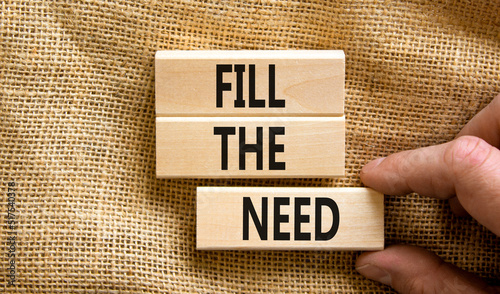 Fill the need symbol. Concept words Fill the need on wooden blocks on a beautiful canvas table canvas background. Businessman hand. Business, finacial and fill the need concept. Copy space.