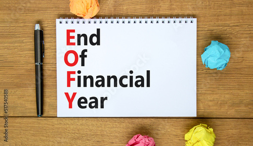 EOFY end of financial year symbol. Concept words EOFY end of financial year on the note on beautiful wooden background. Black calculator and pen. Business and EOFY end of financial year concept.