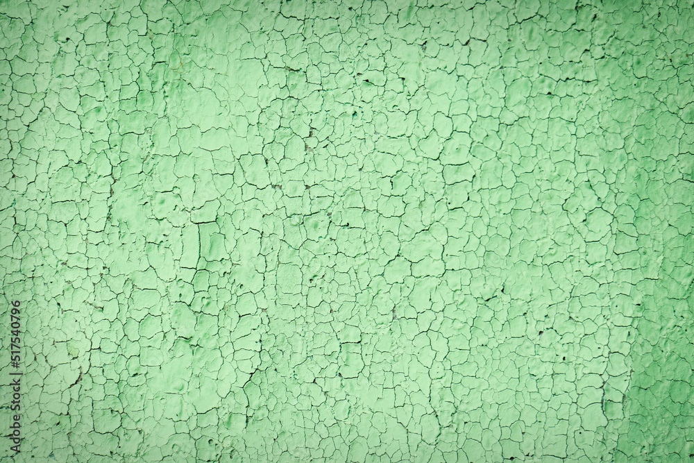 Texture of cracked light green wall as background, closeup