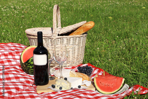 Fototapeta Naklejka Na Ścianę i Meble -  Picnic blanket with delicious food and wine outdoors on summer day