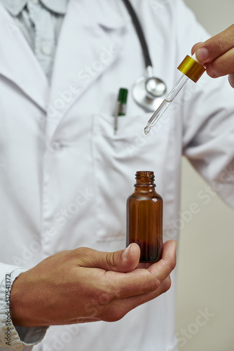 Doctor holding dropper with medicine essential oil