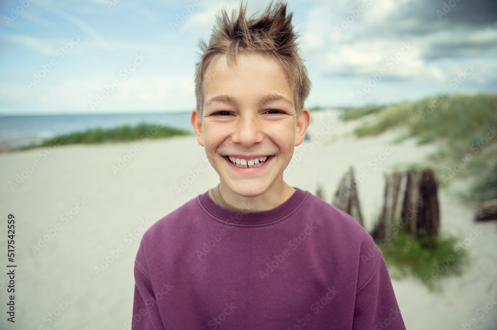 Portrait of handsome teenage boy on beach with white sand at summer day Portrait of handsome teenage boy on beach with white sand at summer day