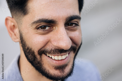 Smiling caucasian young bearded man in formal outfit looking to camera outside on street feel happy businessman portrait business modern manager pretty