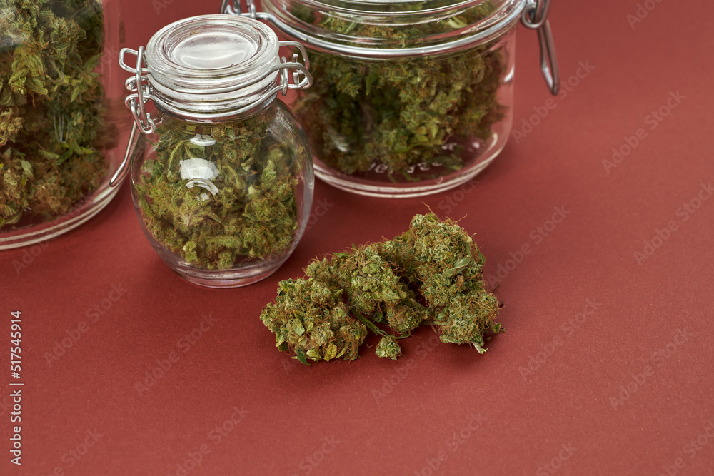 Partial glass jars with dry crushed marijuana buds Partial glass jars with dry crushed marijuana buds