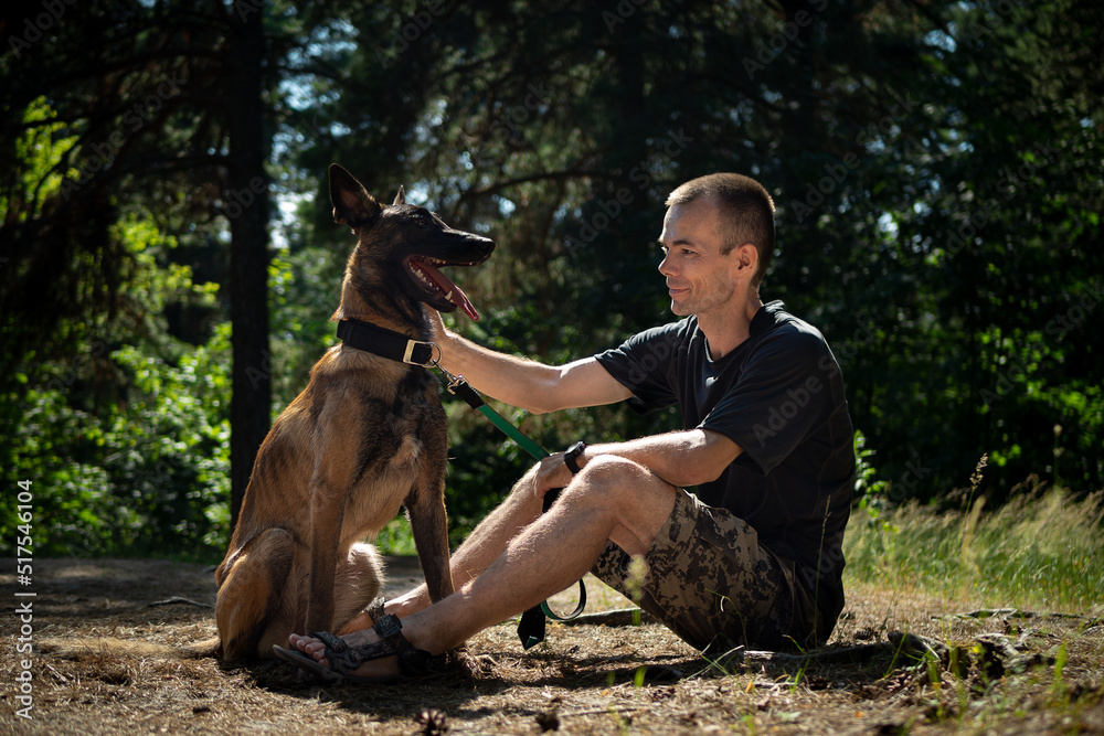 young Caucasian hipster spends time with his dog in the park on a sunny summer day. The concept of a pet as a family member young Caucasian hipster spends time with his dog in the park on a sunny summer day. The concept of a pet as a family member
