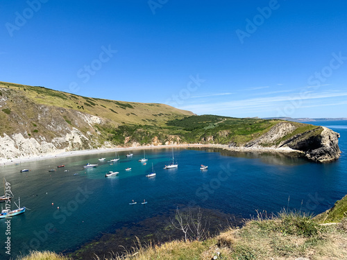 Lulworth Cove bay, beach and cliffs view . The Jurassic Coast is a World Heritage Site on the English Channel coast of southern England. Dorset, UK. crowded beach, public beach. 