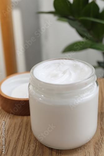 Jar of hand cream on wooden table indoors