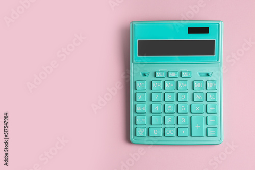 Turquoise calculator on pink background, top view. Space for text