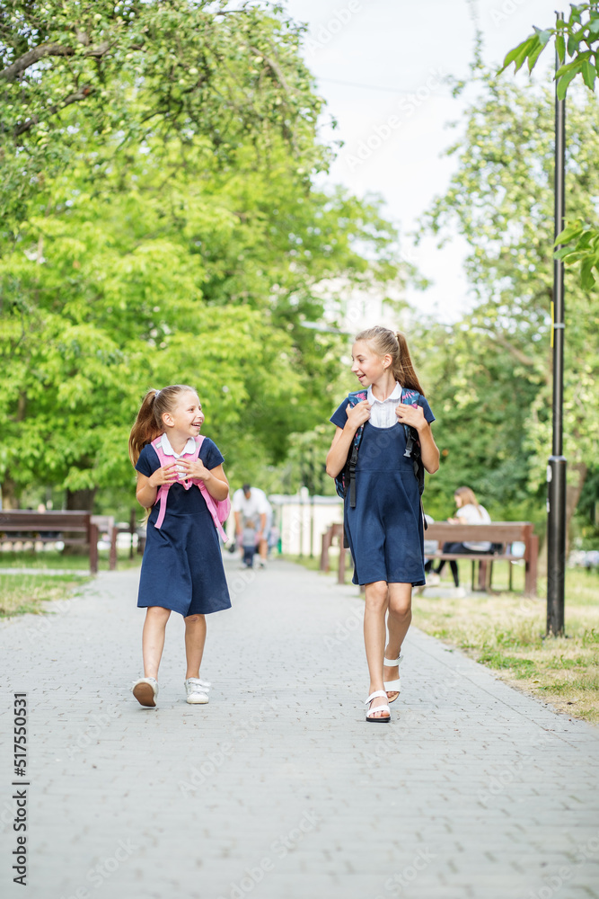 Two children go to school with backpacks. Concept back to school, learning, friendship and childhood Two children go to school with backpacks. Concept back to school, learning, friendship and childhood