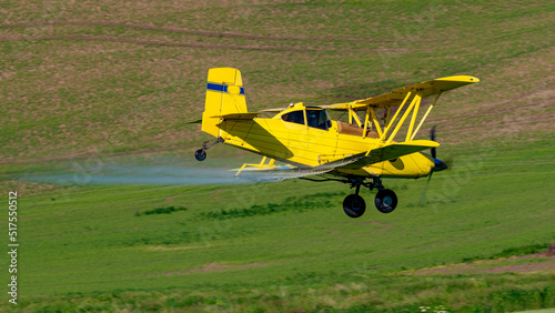 Yellow crop duster over green fields