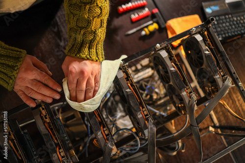 Man wiping cryptocurrency mining rig with rag