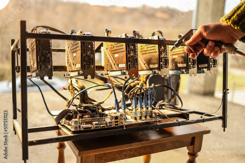 Man cleaning dust from cryptocurrency mining rig with air compressor