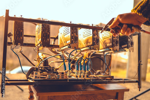Man cleaning dust from cryptocurrency mining rig with air compressor